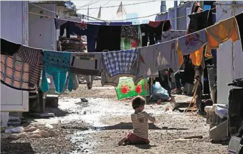  ?? AFP ?? A Iraqi child who fled the violence in the northern city of Tal Afar plays on Wednesday in the alleys of the Bahrka camp for internally displaced people, some 10km west of Arbil, in Iraq’s autonomous Kurdish region .