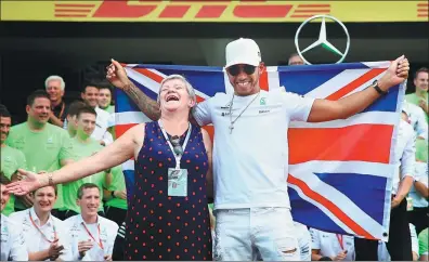  ?? CLIVE MASON / GETTY IMAGES / AFP ?? Lewis Hamilton of Britain and Mercedes GP celebrates with his mother, Carmen Larbalesti­er, after winning his fourth Formula One world title by finishing ninth in the Mexican Grand Prix in Mexico City on Sunday. Hamilton’s nearest championsh­ip rival...