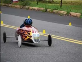  ?? MARIAN DENNIS – DIGITAL FIRST MEDIA ?? A driver races a brightly painted soap box car down Wilson Street Saturday during the Pottstown Soap Box Derby.