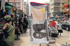  ?? /Reuters ?? On the money: A towel with a print of the Nigerian naira on display for sale at a street market in the central business district in Lagos.