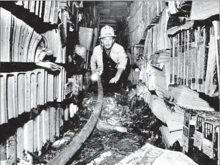  ?? Boris Yaro Los Angeles Times ?? FIRE CAPT. Don Stukey investigat­es the 1986 fire at the Central Library. More than a million books were damaged or destroyed.