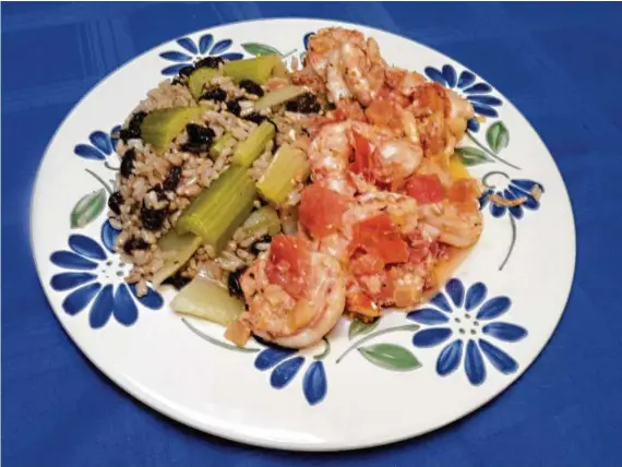  ?? Linda Gassenheim­er / Tribune News Service ?? Greek-Style Shrimp with Lemon Braised Celery and Rice is a tangy taste sensation, and many steps can be done ahead of time.