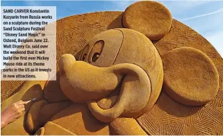  ??  ?? SAND CARVER Konstantin Kuzyarin from Russia works on a sculpture during the Sand Sculpture Festival “Disney Sand Magic” in Ostend, Belgium June 22. Walt Disney Co. said over the weekend that it will build the first ever Mickey Mouse ride at its theme...