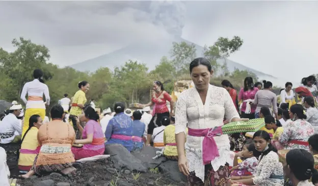  ?? PICTURE: AFP/GETTY IMAGES ?? 0 Villagers gather near Mount Agung, where a volcano on the island of Bali sent plumes of grey smoke and steam thousands of metres into the air