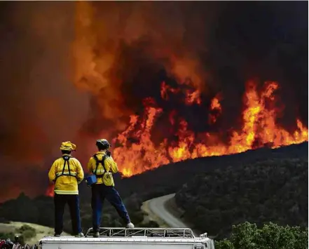  ??  ?? Bombeiros assistem ao incêndio batizado de Mendocino Complex, que atinge a Califórnia desde o dia 27