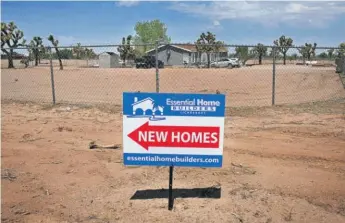  ?? FREDERIC J. BROWN/AFP VIA GETTY IMAGES ?? A sign points to new homes in Hesperia, California, on Thursday.