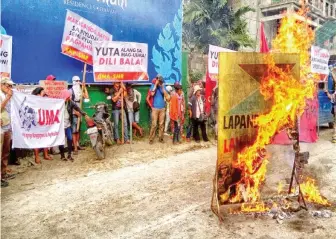  ??  ?? Farmers burn replica of Lapanday's logo to demand its pull-out from their lands in Mindanao in this photo sent by Kilab Multimedia to the regional newspaper Mindanao Examiner.