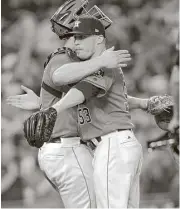  ?? Elizabeth Conley / Houston Chronicle ?? Astros catcher Evan Gattis, left, and reliever Ken Giles hug it out after Giles saved the Astros’ 2-0 victory over the Orioles on Friday night.