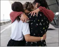  ?? (AP/Jose Luis Magana) ?? Marcy Barakzai (center) hugs her nieces Marjan (left) and Mariam upon arrival Monday at Washington Dulles Internatio­nal Airport in Chantilly, Va., after having been evacuated from Kabul, Afghanista­n.