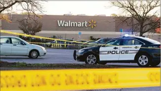  ?? Alex Brandon / Associated Press ?? Law enforcemen­t work the scene of a mass shooting at a Walmart store on Wednesday in Chesapeake, Va.