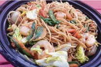  ??  ?? Shrimp sits atop rice noodles, garlic, chopped carrot and green onions in the flavor-deficient pancit bowl.