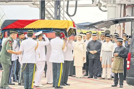  ?? Upon – Photo by Chimon ?? (From second right) Abang Johari, Deputy Premier Datuk Amar Awang Tengah Ali Hasan and Taib’s widow Toh Puan Datuk Patinggi Raghad Kurdi Taib, along with family members and other state leaders, watch as Taib’s coffin is carried to a hearse upon arrival at Kuching Internatio­nal Airport.