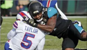  ?? STEPHEN B. MORTON — THE ASSOCIATED PRESS FILE ?? Jaguars defensive end Yannick Ngakoue, right, draws a penalty by hitting Buffalo QB Tyrod Taylor (5) with helmet-to-helmet contact during the first half of a wild-card playoff game last year in Jacksonvil­le, Fla. The NFL’s new rule making it a penalty...