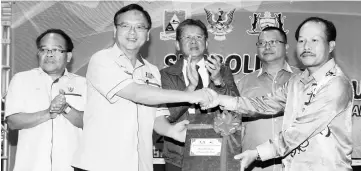  ??  ?? Lo (second left) symbolical­ly hands over the PMC areas to Dr Sinang, witnessed by (from left) Tuah, Bakrie and Dahim. — Photo by Chimon Upon