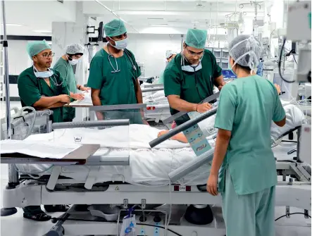  ??  ?? DILIGENT CARE MD students examine a patient at the AIIMS intensive care unit YASIR IQBAL