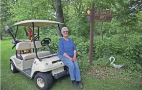  ?? ANGELA PETERSON, MILWAUKEE JOURNAL SENTINEL ?? Lois Schreiter uses a golf cart — loaded with garden tools — to get around her gardens. She and her family made the sign with her name (right) from an old picnic table.