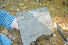  ??  ?? Brackett holds the headstone of Phillis Jack.