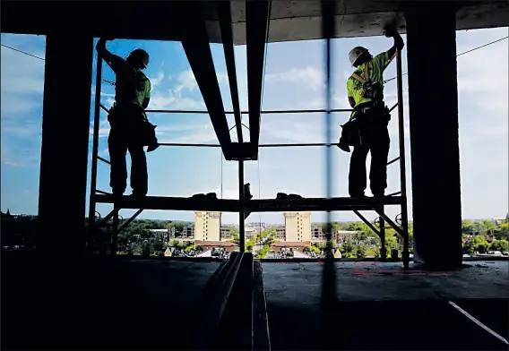  ?? DISPATCH ?? EAMON QUEENEY Michael Chambers, of Dayton, is reflected at the constructi­on site of the Le Meridien Columbus, the Joseph hotel, on High Street in the Short North. Many constructi­on workers retired or otherwise left the industry during the Great...