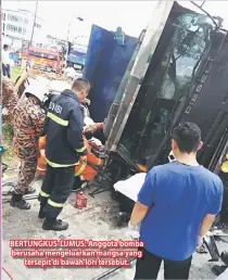  ??  ?? BERTUNGKUS-LUMUS: Anggota bomba berusaha mengeluark­an mangsa yang tersepit di bawah lori tersebut.