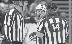  ?? DARRYL DYCK/CANADIAN PRESS VIA AP ?? Blue Jackets center Boone Jenner, back, protests to referee Trevor Hanson, right, after a penalty in a Dec. 14 game.