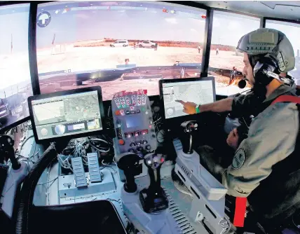  ??  ?? An exhibitor shows the operating suite of an Israeli armoured vehicle during a display of future systems at Elyakim Military Base in northern Israel on Sunday.