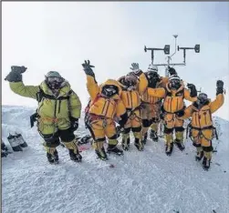  ??  ?? ■ The team celebrates after setting up the world’s highest operating automated weather station. Credit: Mark Fisher, National Geographic.