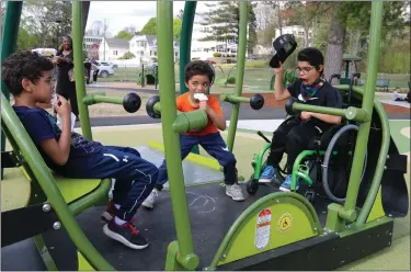  ?? DANIELLE RAY PHOTOS / SENTINEL & ENTERPRISE ?? The Earley brothers of Fitchburg, from left, Nathan, Landon, and Cameron, enjoy playing on one of the handicappe­daccessibl­e play structures at the Sam Pawlak Community Playground following the ribbon cutting on Thursday.