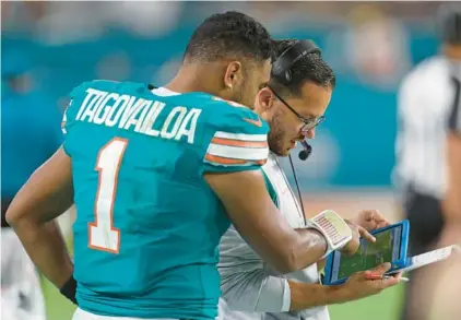  ?? SOUTH FLORIDA SUN SENTINEL FILE ?? Dolphins coach Mike McDaniel, on the sideline reviewing plays with quarterbac­k Tua Tagovailoa, talks the benefits of having his helmet view on camera during OTAs.