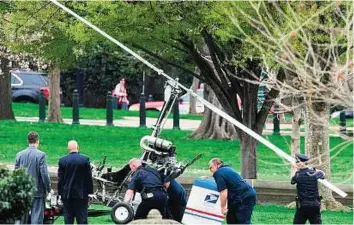  ?? AFP ?? Stunt that went wrong Capitol Hill police officers and other officials lift a gyrocopter that landed on the US Capitol South Lawn on to a trailer on Wednesday in Washington, DC.