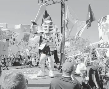  ?? PHELAN M. EBENHACK/ORLANDO SENTINEL ?? Lee Corso reveals whom he projected to win UCF’s showdown with Cincinnati, wearing a Knightro costume at the end of the ESPN College GameDay broadcast on Memory Mall Saturday.