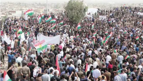  ?? — AFP ?? Iraqis wave Kurdish flags as they gather in support of the upcoming independen­ce referendum and against the parliament’s sacking of the governor of the oil-rich state the previous week during a rally in Kirkuk on Tuesday.