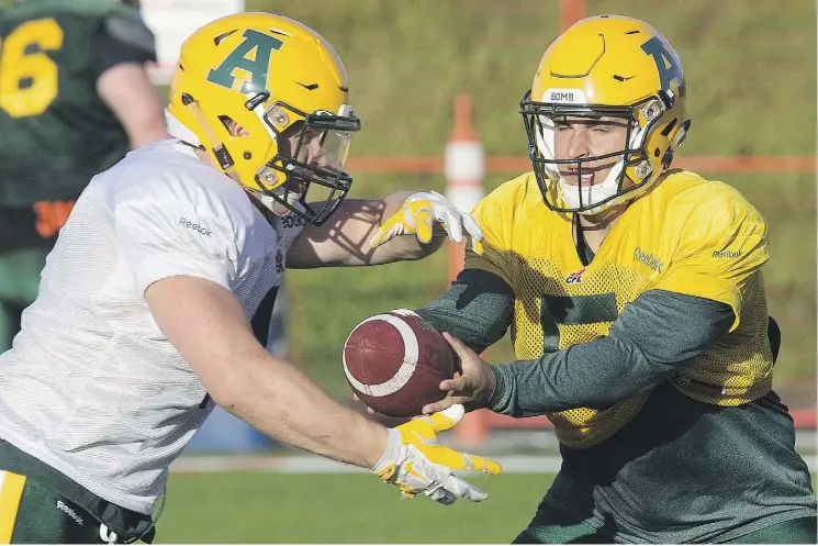  ?? DAVID BLOOM ?? Quarterbac­k Ben Kopczynski hands off to running back Ed Ilnicki during Golden Bears practice at Foote Field in Edmonton on Monday.