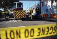  ??  ?? Fire: A firefighte­r carries a hose towards a smoldering building after a fire tore through a warehouse party in Oakland. Oakland Fire Chief Teresa Deloche-Reed said many people were unaccounte­d for.