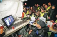  ?? JEAN-PAUL PELISSIER / REUTERS ?? 3. Protesters at a motorway toll booth near Marseille watch French President Emmanuel Macron’s televised address on Dec 10. 3