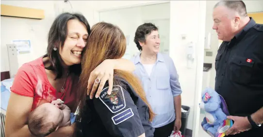  ?? JULIE OLIVER ?? Oksana Shelkovyy hugs dispatcher Sandra Dinel as she meets those who saved her young son’s life, including personal support worker Geraldina Carvalho and parking officer Dave McEvoy. They and others were involved in providing cardio pulmonary resuscitat­ion after the baby stopped breathing last week. Nikita recovered and was released from CHEO Monday.