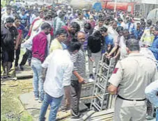  ??  ?? People showing a cop the sewer where the mishap took place at TDI City; (right) cops trying to disperse victims’ family members, who blocked the national highway in Sonepat on Monday.