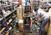  ?? JUN HIRATA/KYODO NEWS VIA AP ?? A liquor shop’s manager clears the damaged bottles following an earthquake in Fukushima, northeaste­rn Japan on Saturday.