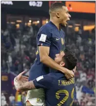  ?? (AP/Martin Meissner) ?? France’s Kylian Mbappe (left) celebrates with teammate Theo Hernandez after giving his team a 1-0 lead against Denmark in the first half Saturday in Doha, Qatar. Mbappe scored both of France’s goals in a 2-1 win. More photos at arkansason­line.com/1127wcup22/