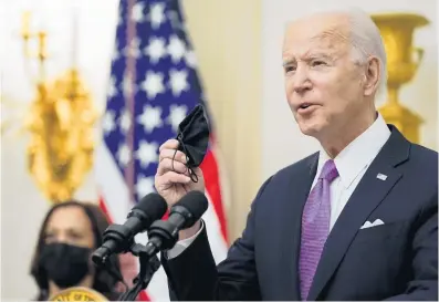  ?? ALEX BRANDON/AP ?? President Joe Biden holds a face mask as he speaks about the coronaviru­s in the State Dining Room of the White House on Thursday in Washington.