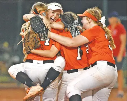  ?? STAFF PHOTO BY ROBIN RUD ?? Meigs County softball players embrace after the final out of the program’s third state championsh­ip in three years in Murfreesbo­ro.