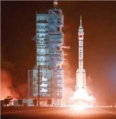  ?? — AFP photo ?? A Long March-2F carrier rocket, carrying the Shenzhou-18 spacecraft and a crew of three astronauts, lifting off from the Jiuquan Satellite Launch Centre in the Gobi desert in northwest China.