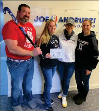  ?? COURTESY DAWN DELUCA ?? Leominster resident Dawn Deluca (second from left) and Gardner High School field hockey coach Lynn Sayarath (far right) present a $2,017 check to Joe Andruzzi (far left) and his wife Jen Andruzzi at the
Joe Andruzzi Foundation headquarte­rs in North Attleborou­gh, the results of last year’s annual Stick It To Cancer field hockey game fundraiser.