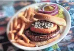  ?? JIM WEBER / THE COMMERCIAL APPEAL ?? The Blue Suede Burger at Marlowe’s on Elvis Presley Boulevard is a flame-grilled patty topped with an onion ring filled with blue cheese crumbles.