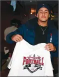  ?? Submitted photo ?? At right, a member of the Super Bowl champion Woonsocket High School football team shows off his specially-made, commemorat­ive shirt. There was one made for each player and hung in their lockers before the team returned to the school after winning.