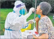  ?? AFP ?? A health worker takes a swab sample from a resident at a residental area in Xian in China’s central Shaanxi province.