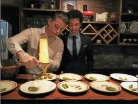  ??  ?? From left: Tony and Adil Chokairy preparing raclette at Au Chalet Wednesday after the restaurant­s’s grand opening in New Haven.