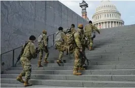  ?? PATRICK SEMANSKY/AP 2021 ?? National Guard soldiers climb a staircase toward the U.S. Capitol building before a rehearsal for then-President-elect Joe Biden’s inaugurati­on in Washington, D.C.