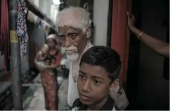  ?? MOHD RASFAN/AFP/GETTY IMAGES ?? Rohingya migrants originally from Burma stand in an alley in Kuala Lumpur on Wednesday, where they now reside. In the past three weeks, more than 3,000 people have fled Burma and Bangladesh in crowded boats.