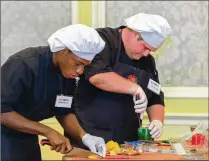  ?? DAMON HIGGINS / THE PALM BEACH POST ?? Fort Pierce Westwood High students Sheldon Riley (left) and James Weichmann compete in the Fresh From Florida Student Chef CookOff at The Breakers in Palm Beach on Tuesday. The duo advances to the Jan. 30 finals in Tallahasse­e.