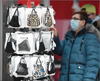  ?? (AFP) ?? A woman looks at face masks on sale in a shop at the city of Dortmund, Germany, on Wednesday.